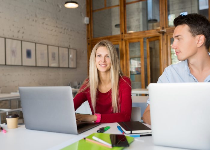 busy young man and woman working on laptop in open space co-working office room, busy freelancers